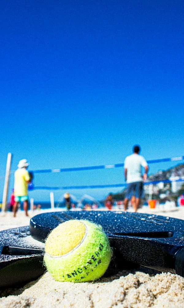 Raquete e bola de beach tennis na areia